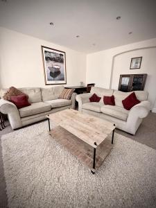 a living room with two couches and a coffee table at Churchgate Apartment in Bury Saint Edmunds