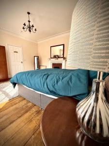 a bedroom with a bed and a table with a lamp at Churchgate Apartment in Bury Saint Edmunds
