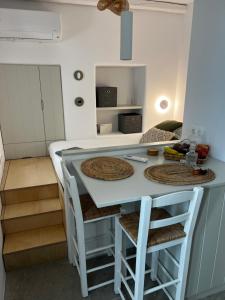 a kitchen with a counter and a island with stools at Lefteris Home in Parikia +5 photos