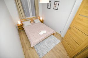 a small bedroom with a bed and a wooden door at JJ Apartment Zator Energylandia in Zator