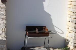 a grill sitting on a table next to a wall at Charmante Maison Pierres 1768 in Polisy