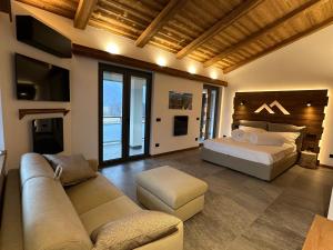 a large bedroom with a bed and a couch at Valtellina SkyLine EST in Villa di Tirano