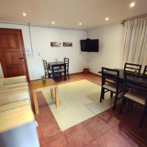 a living room with a table and chairs and a television at Hosteria Puyehue in San Carlos de Bariloche