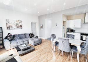 a living room with a couch and a table and chairs at Stylish & Modern 2BR Flat nr Nottingham City Centre in Nottingham