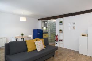 a living room with a couch and a table at Apartamento Dormitalería in Pamplona +8 photos