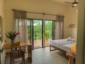 a bedroom with a bed and a table and a sliding glass door at Maze Lodge - Boutique Hotel in Puerto Jiménez