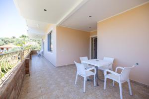 a room with a table and chairs and a balcony at Villa Yucca in Vlorë