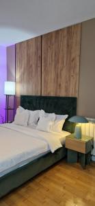 a bedroom with a large bed with a wooden headboard at Penthouse View Aeroport Iasi in Iaşi