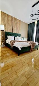 a bedroom with a large bed and a wooden floor at Penthouse View Aeroport Iasi in Iaşi