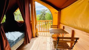 吉莱斯特尔Camping Onlycamp la Rochette的一个帐篷，甲板上有两把椅子和一张长凳 更多5张照片
