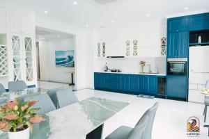 a kitchen with blue cabinets and a table and chairs at Latritcia Boutique Hotel in Cat Ba