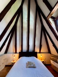 a bedroom with a white bed with two tables at Les Galeries de Beaulac in Pézenas +30 photos