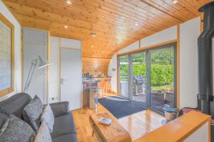 a living room with a couch and a wood ceiling at Brownthwaite Luxury Pod with Hot Tub at Fell View Park Kirkby Lonsdale in Casterton