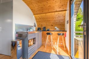 a kitchen in a tiny house with a stove at Brownthwaite Luxury Pod with Hot Tub at Fell View Park Kirkby Lonsdale in Casterton +10 photos