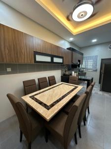 a kitchen and dining room with a table and chairs at Ahnaf Guesthouse in Sitiawan