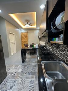 a kitchen with a sink and a table at Ahnaf Guesthouse in Sitiawan +6 photos