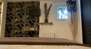 Schlafzimmer mit einem Bett mit einer schwarz-weißen Tapete in der Unterkunft Chambres et tables d hôtes du Boiziller in Saint-Michel-Mont-Mercure