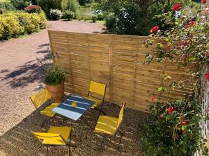 einen Tisch und Stühle in einem Garten mit einem Zaun in der Unterkunft Chambres et tables d hôtes du Boiziller in Saint-Michel-Mont-Mercure