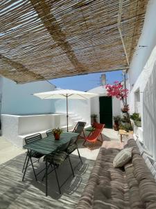 a patio with a couch and a table and chairs at A Casa dos Raminhos in Vila de Frades