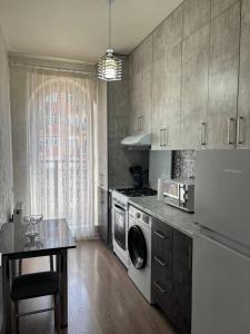 een keuken met een wasmachine en een tafel. bij Comfortable appartment in Salor Bekati