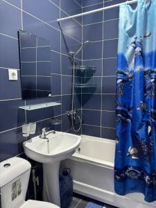 een badkamer met een wastafel, een toilet en een douchegordijn bij Comfortable appartment in Salor Bekati