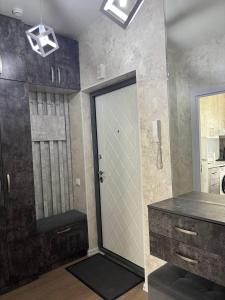 een badkamer met een deur, een wastafel en een spiegel bij Comfortable appartment in Salor Bekati