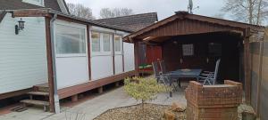 a small cabin with a table on a patio at Ferienhaus Stamer am großen Meer in Bedekaspel
