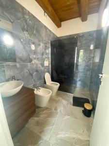 a bathroom with two sinks and a toilet in it at Bed and Breakfast Aida in Cotignola