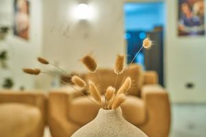 a white vase with some dried plants in it at Favourites home-English breakfast in Arusha