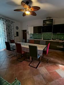 a dining room with a table and chairs and a ceiling fan at Villa Pulcinella in Spoleto