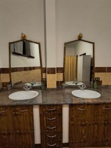 a bathroom with two sinks and two mirrors at Villa Pulcinella in Spoleto +23 photos