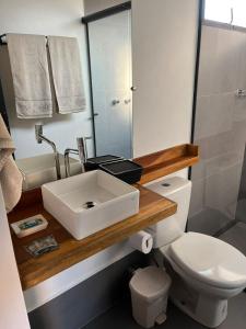 ein Badezimmer mit einem weißen Waschbecken und einer Toilette in der Unterkunft São Roque Chalés 2 - Pet Friendly in São Roque