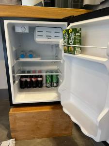 einen offenen Kühlschrank mit Getränken und Soda in der Unterkunft São Roque Chalés 2 - Pet Friendly in São Roque