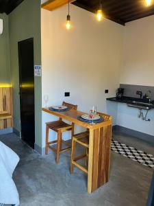 eine Küche mit einem Holztisch mit Weingläsern darauf in der Unterkunft São Roque Chalés 2 - Pet Friendly in São Roque