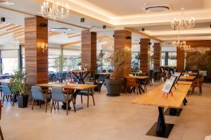 ein Restaurant mit Holztischen und -stühlen und Fenstern in der Unterkunft Lago Hotel & Spa - Adult Recommended in Ohrid