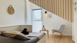 Un dormitorio con una cama y una silla dentro. en Studio L'Essentiel - Parking & Wifi, en Troyes