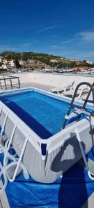 a boat with chairs next to a swimming pool at Blue Marina Apartments in Marina