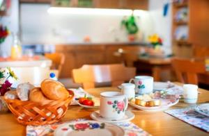 a table with a basket of bread and cups on it at TAMERBURGERHOF in Lienz +30 photos