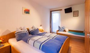 a bedroom with a bed with blue and white pillows at TAMERBURGERHOF in Lienz