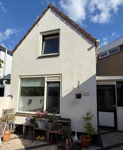 una casa blanca con macetas delante de ella en Noordwijk Sur-Mer, en Noordwijk aan Zee