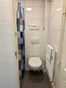 Un pequeño baño con inodoro y ducha. en Noordwijk Sur-Mer, en Noordwijk aan Zee 9 fotos más