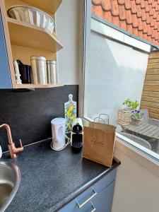 Una encimera de cocina con un fregadero y una ventana. en Noordwijk Sur-Mer, en Noordwijk aan Zee