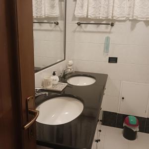 a bathroom with two sinks and a mirror at Affittacamere Il Conte in Follonica