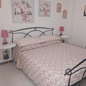 a bedroom with a bed and two tables with lamps at Affittacamere Il Conte in Follonica +19 photos