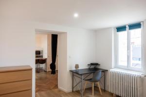 オルレアンにあるLa cour de Jeanneのテーブルと窓のあるリビングルーム +2枚の写真