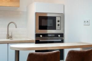 オルレアンにあるLa cour de Jeanneのキッチン(電子レンジ、テーブル、椅子付)