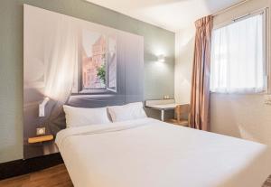 A bed or beds in a room at B&B HOTEL Strasbourg Sud Geispolsheim