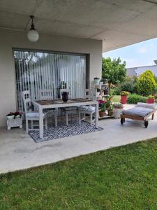 a patio with a table and two chairs and a bench at Habitación en casa moderna con jardín in Santa Cruz de Bezana