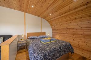 a bedroom with a bed and a wooden wall at Ellerbeck Luxury Pod with Hot Tub at Fell View Park Kirkby Lonsdale in Kirkby Lonsdale