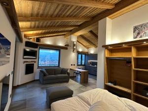 a room with a bed and a couch and a kitchen at Valtellina SkyLine OVEST in Villa di Tirano